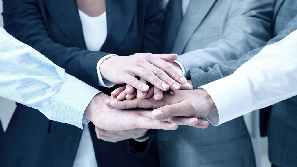 Personen, die Hände aufeinanderlegen